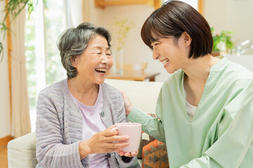 自宅 一緒にお茶を飲む祖母と孫