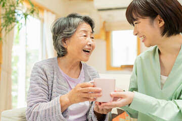 Obraz na płótnie Canvas 自宅 一緒にお茶を飲む祖母と孫