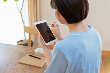 タブレットで日誌を書く女性医療従事者