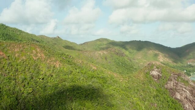 Aerial view of the nature of the Seychelles islands. Mountain ranges with slopes and peaks. Jungle forests with exotic plants. High quality 4k footage