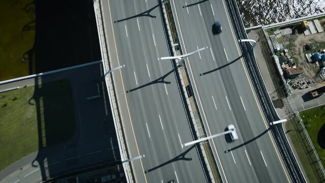 Aerial view of the ZSD Highway and the Cable-stayed Bridge next to the Flagpole and Grassland, Park on the banks of the Neva, camera down
