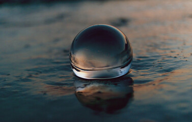 drops of sea water on crystal sphere at sunset