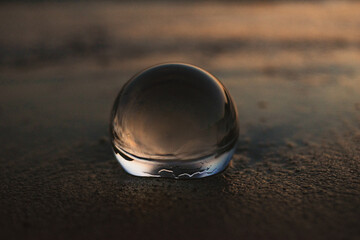 crystal sphere with sunset reflection at the beach