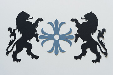decorative rosette and two black paper heraldic lion glyphs or dingbat silhouettes