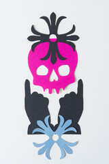 skull head, pointing fingers up, and rosettes on blank paper