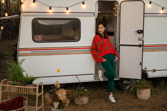 Caucasian Woman In Oversized Red Knitted Jumper Travels In Motorhome In Autumn. 