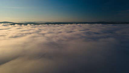 Fototapeta na wymiar Early Sunrise and Horizon over the clouds cover mountains ridge