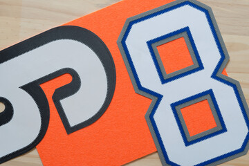 sports jersey numbers on orange felt and wood