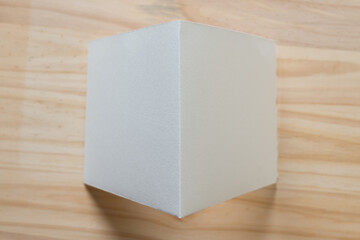folded paper standing on wood - photographed from above