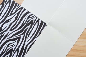 folded out paper with creases and striped black and white card stock