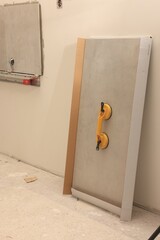 Yellow suction plate attached to tile near wall