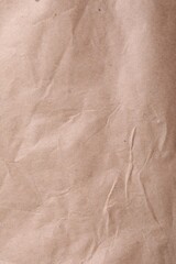 Texture of wrinkled kraft paper bag as background, closeup