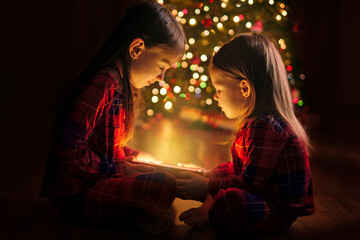 The sisters are holding a box with a magical glow from the inside sitting on the floor by the...