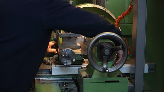The operation of lathe machine cutting the metal shaft parts. The metalworking process by turning machine and changing tools