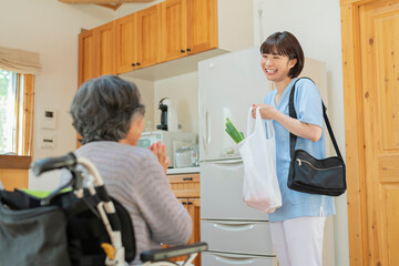買い物代行をする女性介護士と利用者の女性 © One
