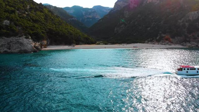 R&uuml;ckw&auml;rtsflug w&auml;hrend Kreuzfahrt und Segelboot Schiff an der K&uuml;ste der Insel Sardinien bei Olbia &uuml;ber das Meer in einer Bucht im Urlaub fahren 4k