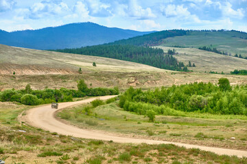 Fototapeta na wymiar The road in the area of the Saxon Castle of Savinsky is the main natural attraction of the Barguzin Valley of the Trans-Baikal Territory of the Republic of Buryatia.