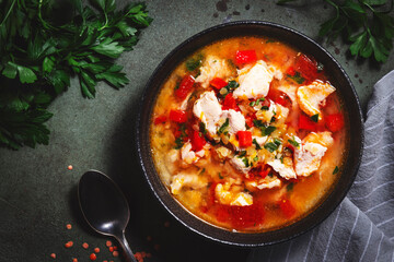 Warming autumn soup with red lentils, chicken fillet, vegetables, spices and paprika, comfort food. Green table, top view