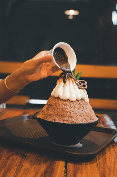 Hand taking a fruit ball from Bingzu korean shave ice, Woman diet with healthy eating concept.