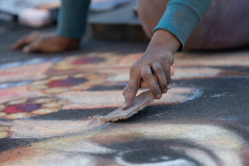 Artist drawing at a chalk art festival © john