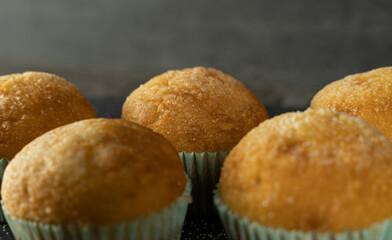 Set of delicious freshly baked cupcakes with sugar on top on a background