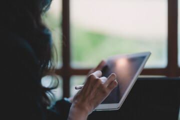 Young businesswoman using technology about laptop and tablet for reading, job, work, studying at cafe. Asia woman lifestyle using internet and wireless.