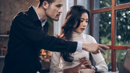 Two young business people work together in office. Concept of presentation new idea business project. Designer offers a job to a young businesswoman.