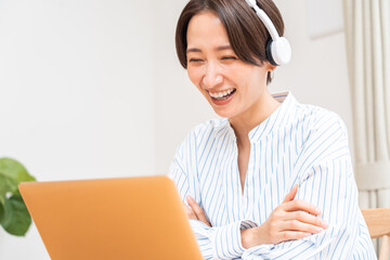 パソコンに向かって話すヘッドホンをつけた日本人女性