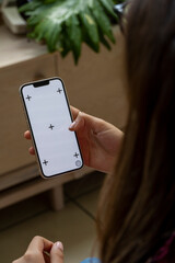 phone with green screen, in a warm home environment, held by a latina woman's hand