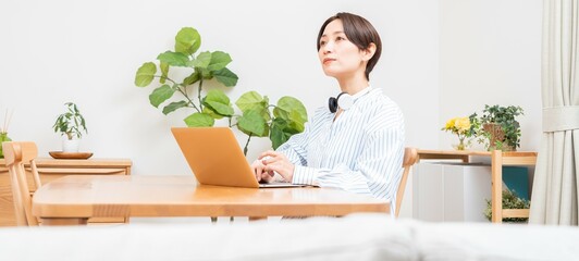 ヘッドホンをつけ考え事をする日本人女性