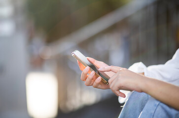 woman using smartphone for online shopping on green nature background in the outdoor park.