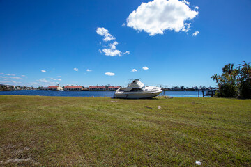 Fototapeta premium Boat in field damaged during storm surge in Cape Coral because of Hurricane Ian