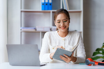 Beautiful young Asian woman student are reading book and taking notes of their studies and the details of their studies in order to submit reports to teachers.