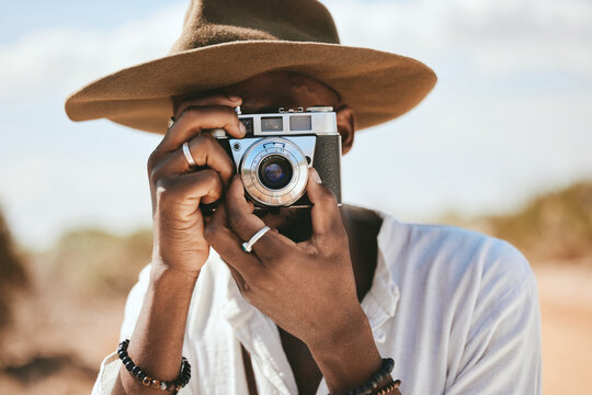 Tourist, photographer and black man with camera to take photograph or pictures during travel adventure in summer on nature vacation. Closeup of male on photography trip holiday outdoors in safari