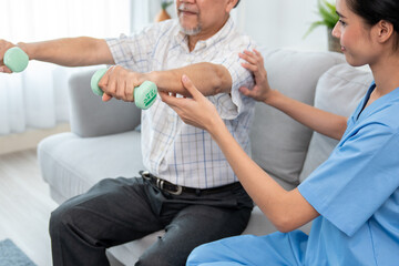 Contented senior patient doing physical therapy with the help of his caregiver. Senior physical therapy, physiotherapy treatment, nursing home for the elderly