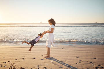 Mother, girl spinning and family at the beach playing together in the sunshine. Mom and young fun child in summer sunlight bonding at sea water waves and beach sand feeling happy outdoor on vacation