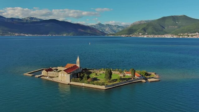 Aerial around view of the island of Notre Dame de la Misericorde, monastery in the Bay of Kotor, Montenegro. Ostrvo Gospa od Milosrda, 4k