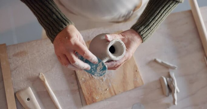 Clay, creative and pottery with hands of woman sculpting at ceramics workbench for art, design and workshop studio. Craftsman, artist or entrepreneur molding vase for hobby or small business