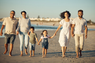 Family on beach with children smile while parents, kids grandparents holding hands on vacation by the ocean. Black family walking in sand by the sea, show love and bonding on holiday or reunion