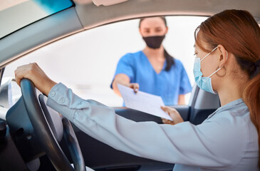 Covid test in car and drive thru, nurse giving patient forms to fill in. Woman in vehicle wearing a mask and taking documents from medical worker. Masks, coronavirus and testing on remote site