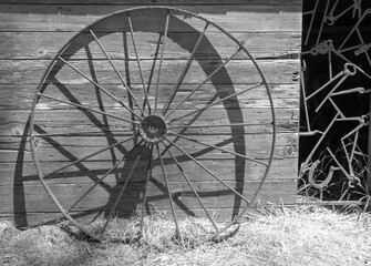 Fototapeta na wymiar Black and white picture of rusted iron wheel in front of abandoned tool shed on Santa Cruz Island in the Channel Islands National Park near Santa Barbara California in the United States