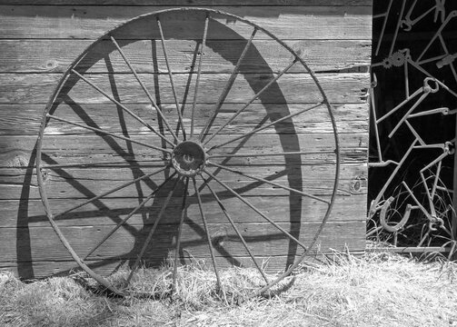 Black and white picture of rusted iron wheel in front of abandoned tool shed on Santa Cruz Island in the Channel Islands National Park near Santa Barbara California in the United States