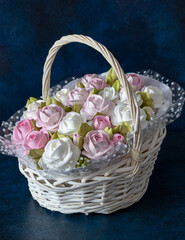 Fototapeta na wymiar Zephyr bouquet of flowers in a basket on a dark blue background background. homemade confectionery. healthy and beautiful food.