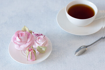 tea set in a composition with marshmallow flowers. Coffee mug on a saucer. on a light gray background