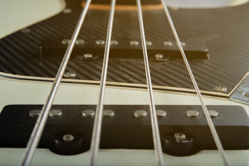Close up guitar bass string details , four iron strings, white and black color