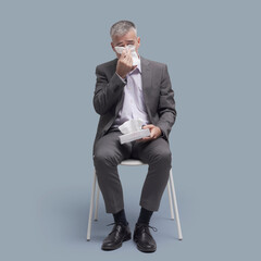 Patient with cold and flu sitting on a chair