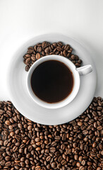 Cup of coffee and coffee beans, flat lay.