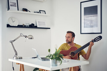 Man playing acoustic guitar at home.