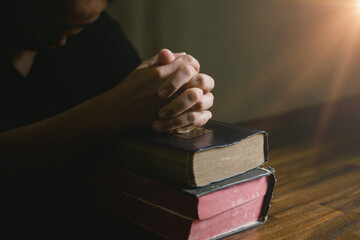 Prayer person hand in black background. Christian catholic woman are praying to god in dark at...