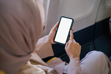 Asian muslim businesswoman working on digital laptop computer during the flight for her business trip. Business and transportation concept